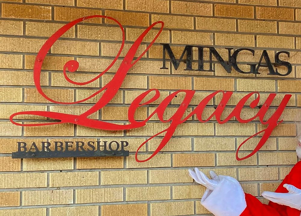 The red Minga's Legacy script sign on the shop's brick wall